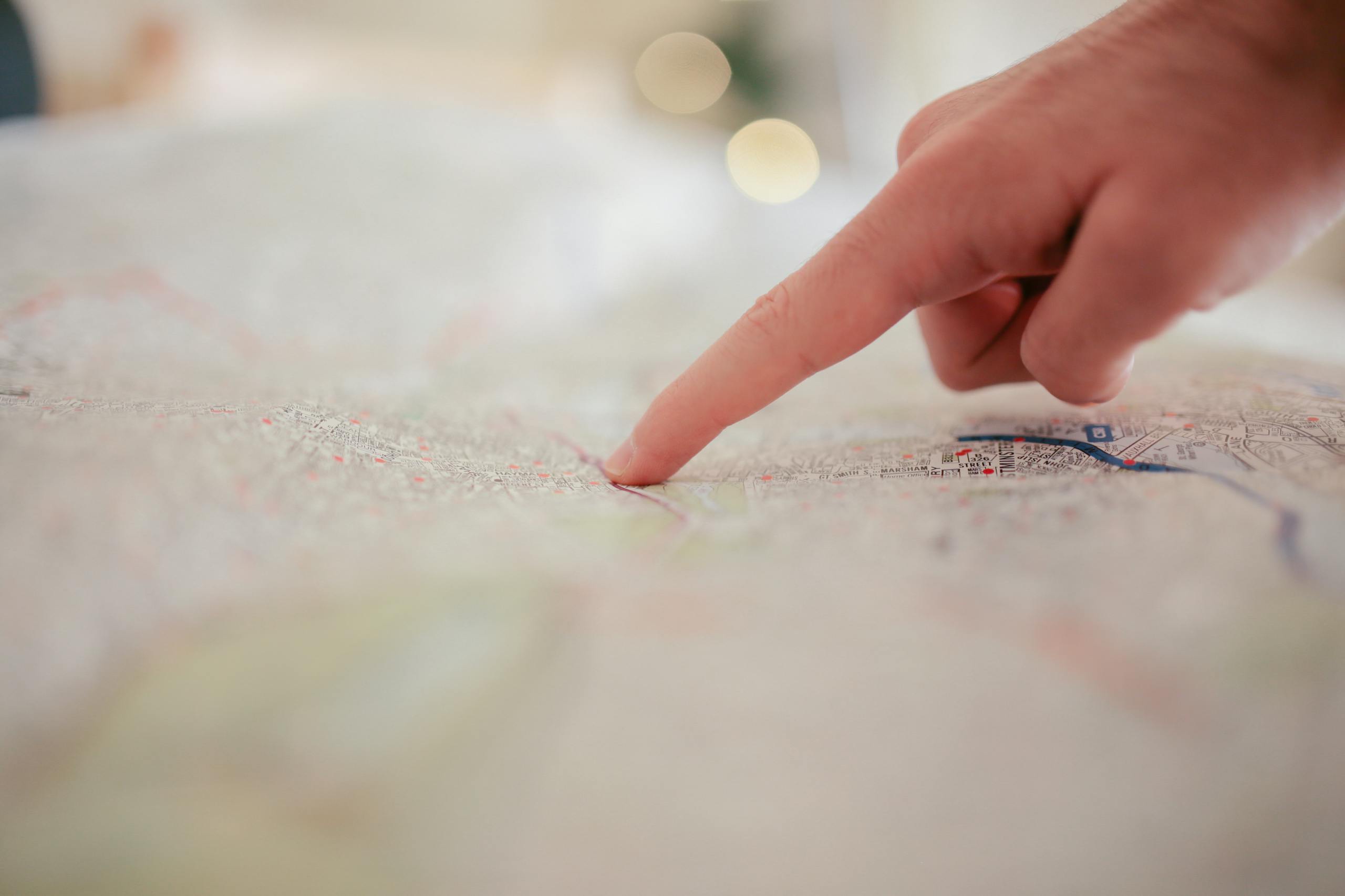 A hand pointing at a city map, highlighting direction and navigation planning.