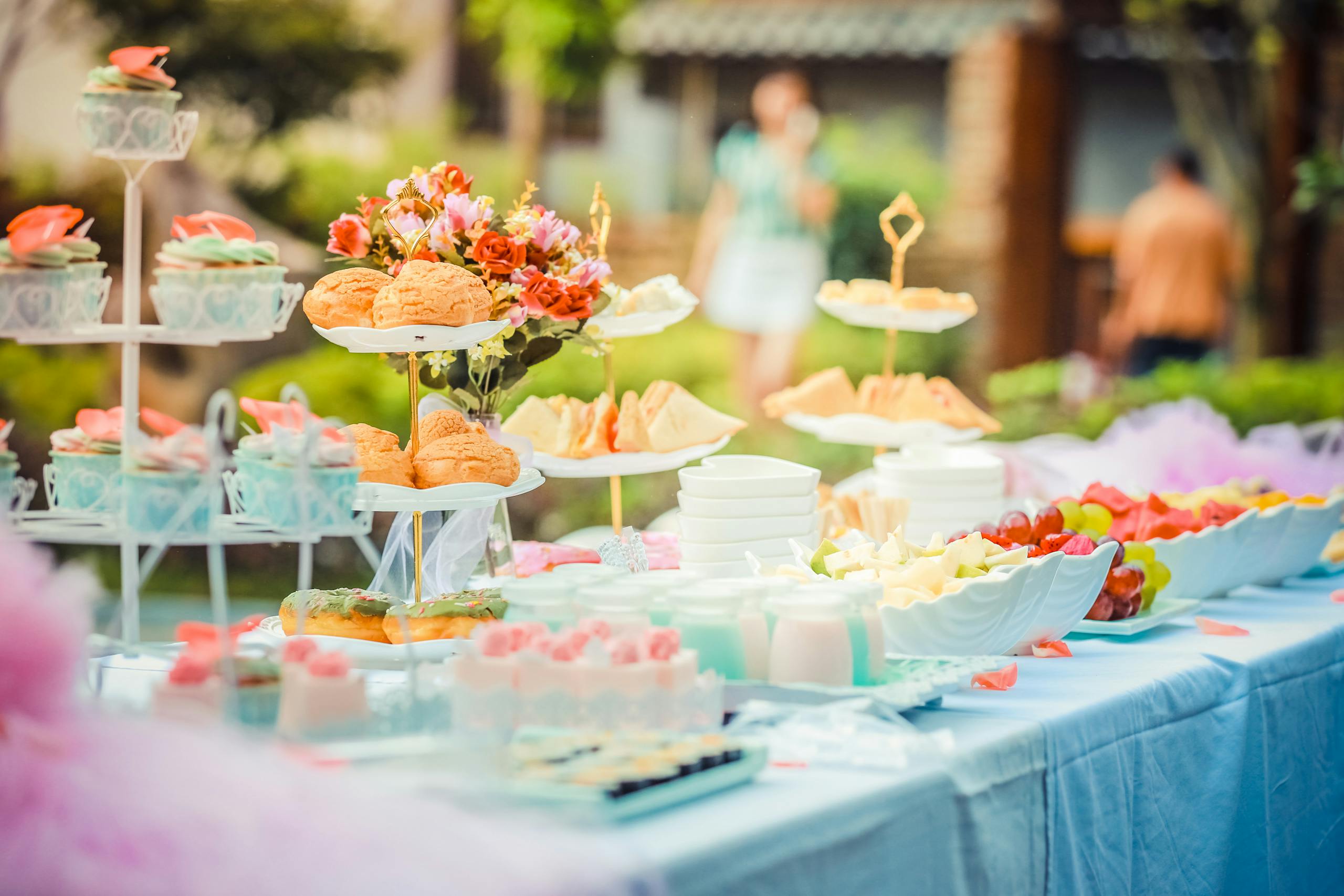 A vibrant outdoor buffet table showcasing an array of colorful pastries and fruits, perfect for parties.